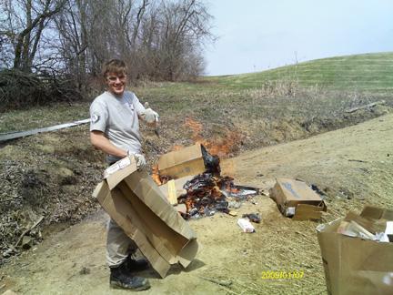 Article Thumbnail. Trenton Kraczek is burning  trash at Camp Echoing Hills in Warsaw, OH. 