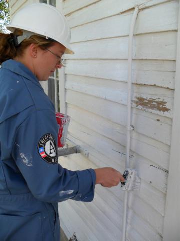 Article Thumbnail. Brittney Springer working on the West Branch School, the first building the team completed.